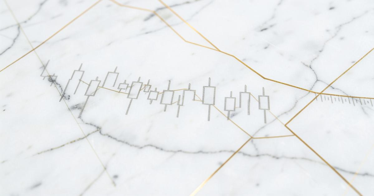 Engraved candlestick chart on polished white marble with gold trend lines